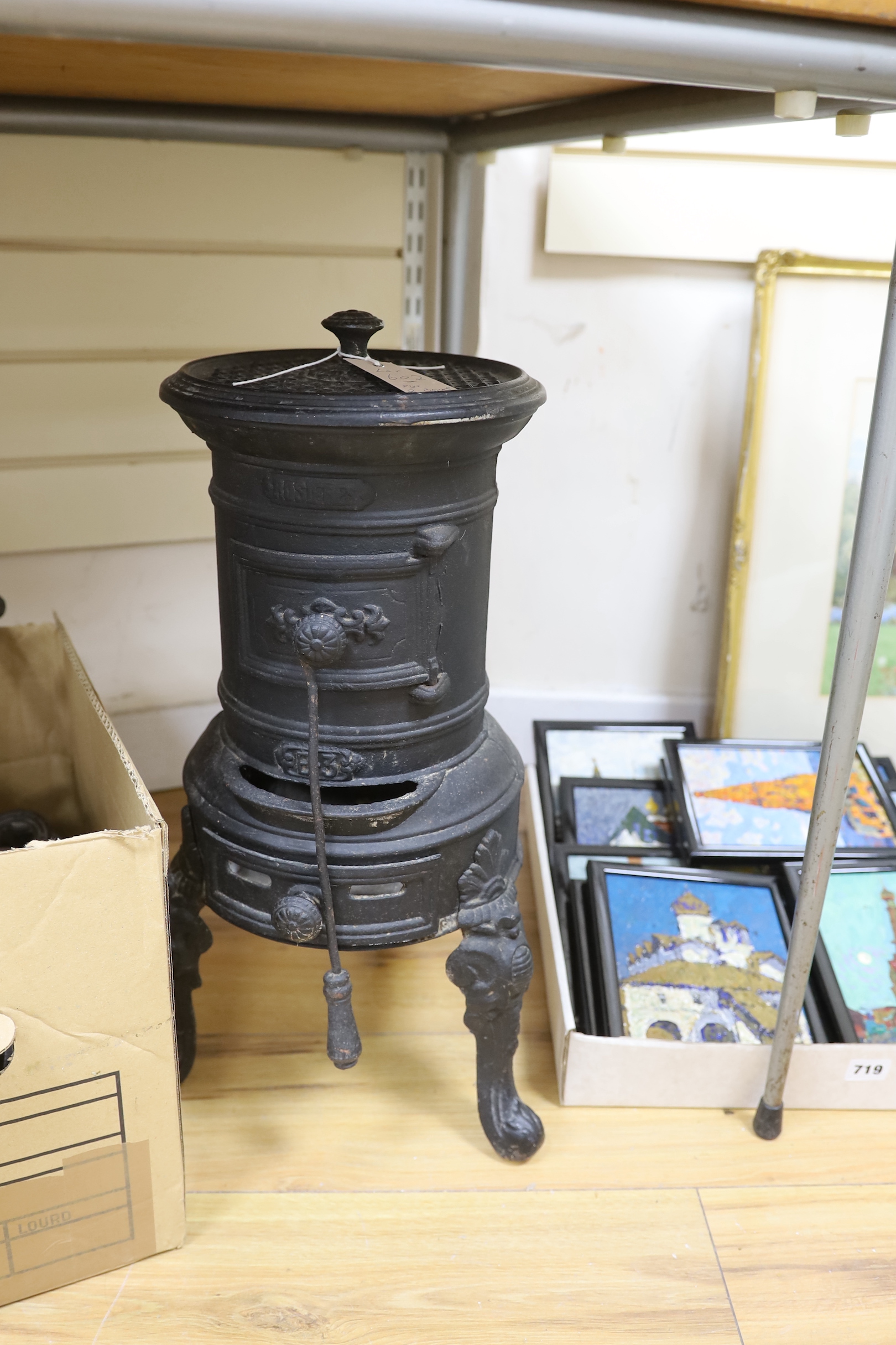 A collection of vintage domestic iron implements, including a cylindrical iron stove